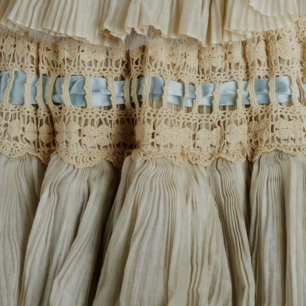 Close up of a Sybil Connolly cream dress with blue ribbon